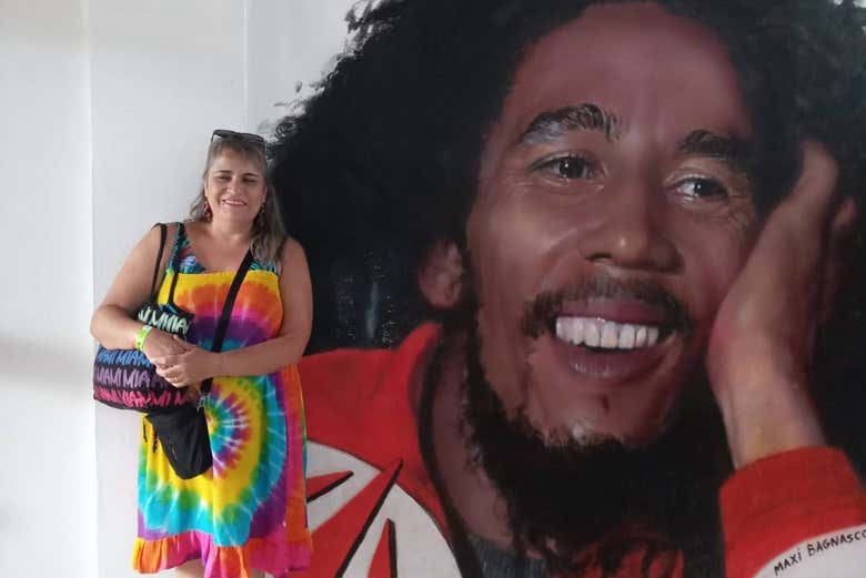 Posando junto a um grafite do cantor