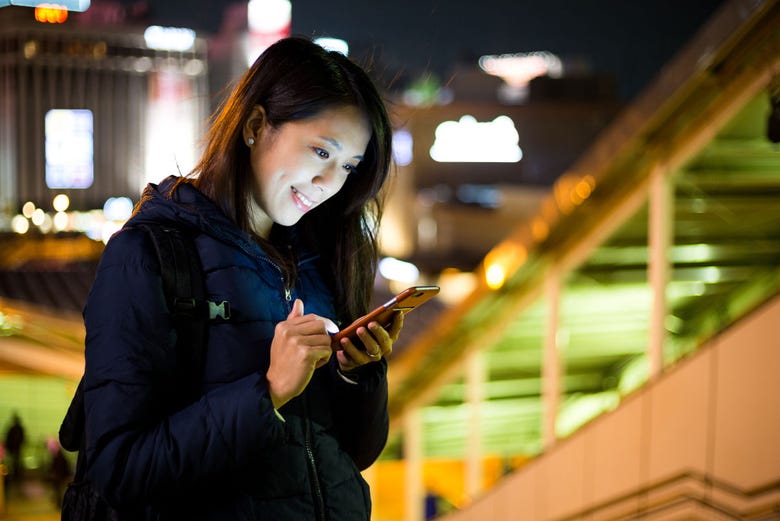 Mulher olhando o celular em Tóquio