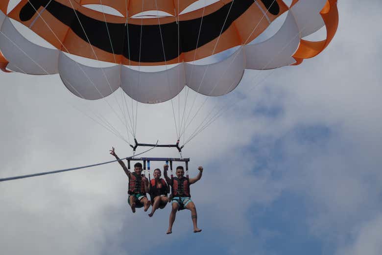 Tres personas disfrutando de la experiencia en parasailing