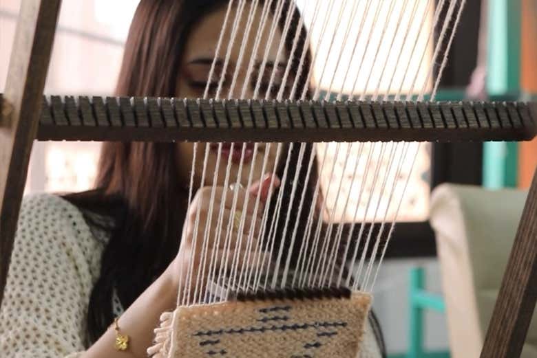 Siguiendo las indicaciones del maestro tejedor en el telar