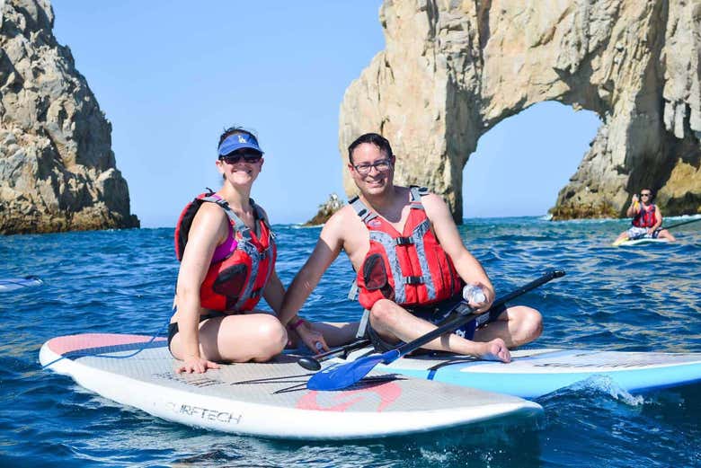 Un par de amigos sentados sobre las tablas de paddle surf