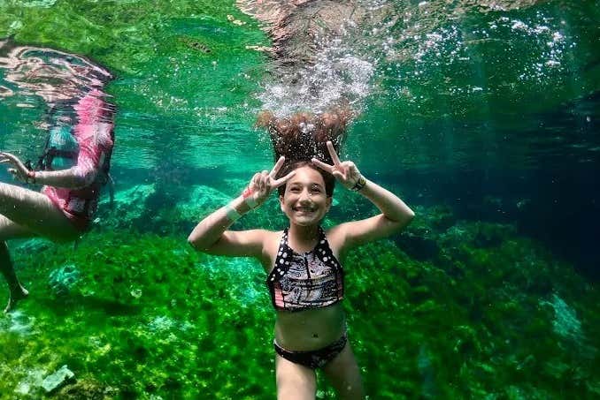 Una niña en las aguas del cenote