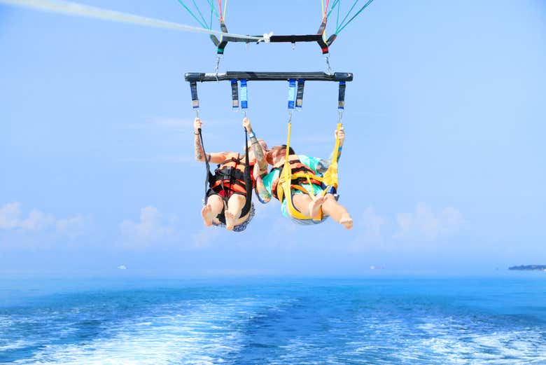 Pareja montando en parasailing