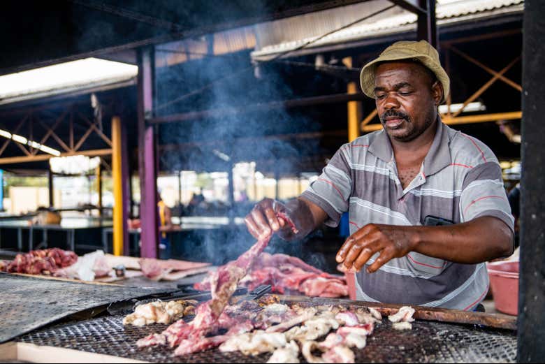 Un vendeur local cuisinant de la viande
