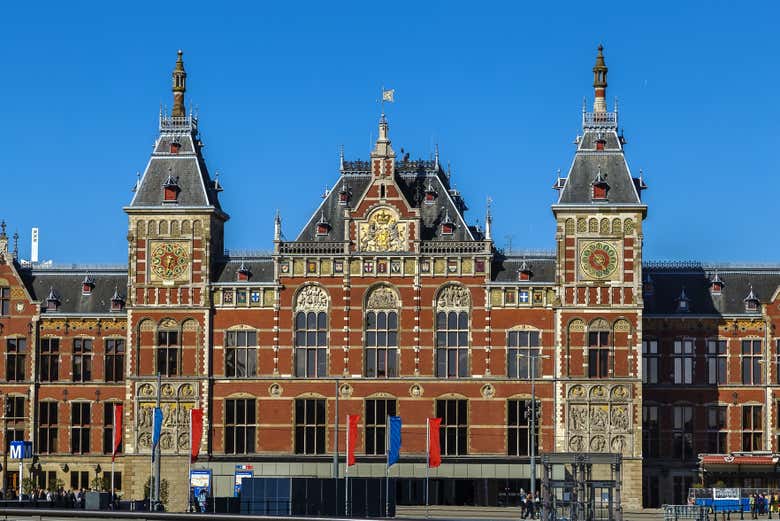Cycle past the impressive Amsterdam Centraal Station