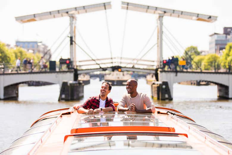 Hombres asomados en el barco por los canales de Ámsterdam