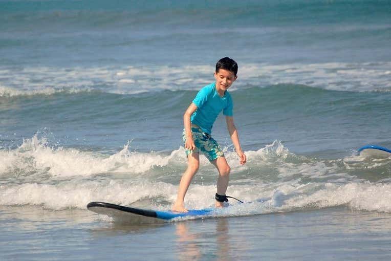 Criança pegando ondas