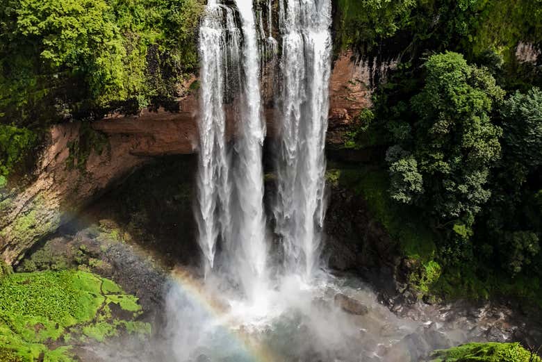 Un arcoíris en la laguna natural de la cascada Kiki