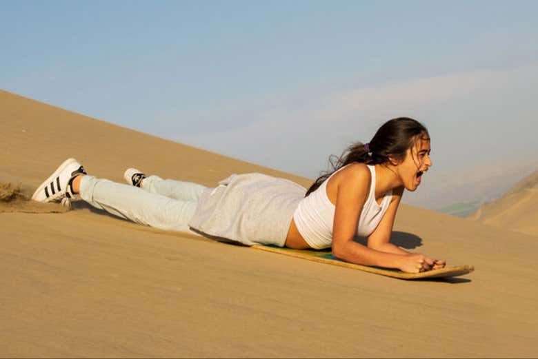 Deslizándose en sandboard por las dunas