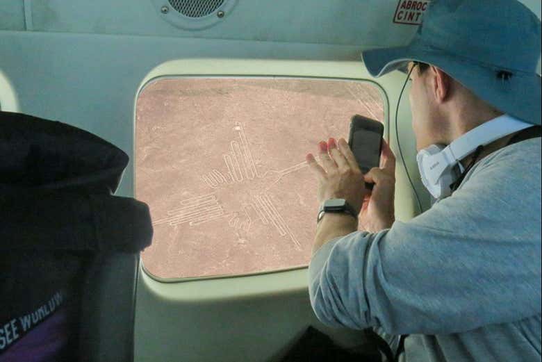 Un chico fotografiando las líneas de Nazca desde la avioneta