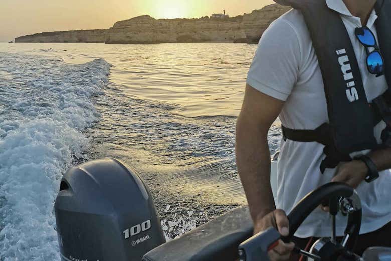 Pilotando la embarcación al atardecer por las cuevas de Benagil