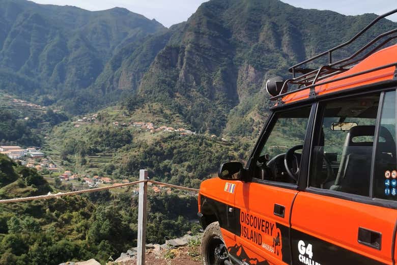 An orange jeep with a view of the mountains