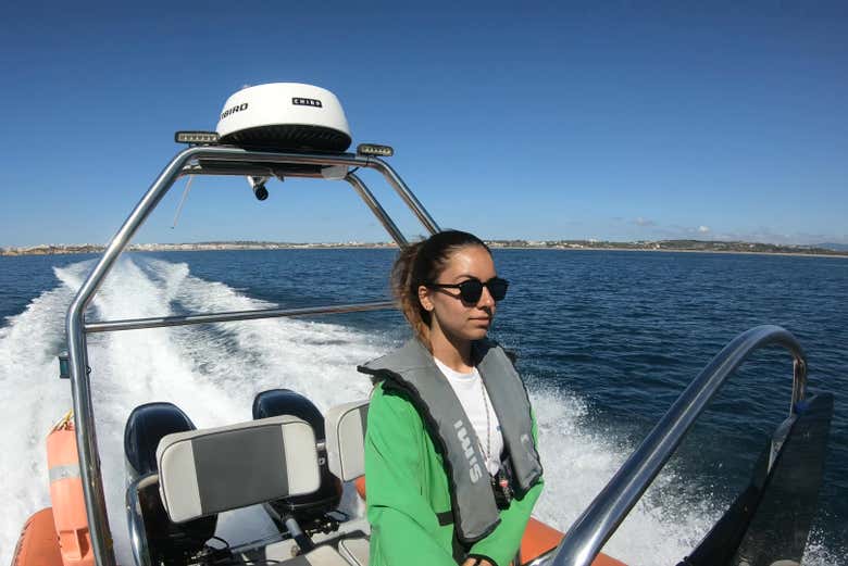 Una mujer a bordo de una lancha por la costa de Algarve