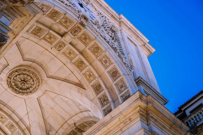 Look up at the intricate stonework of the Arco da Rua Augusta