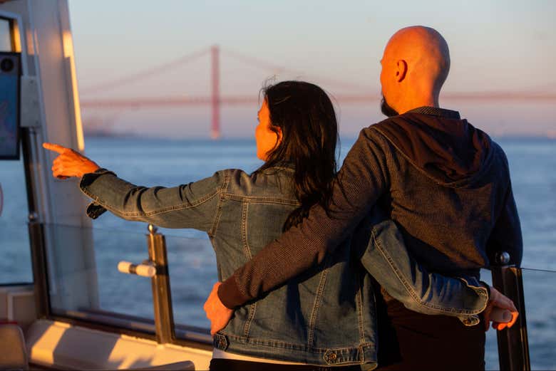 Casal desfrutando do pôr do sol no barco