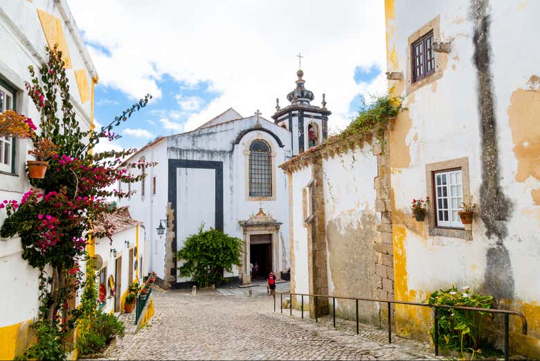 Hermosa calle de Óbidos con iglesia de San Pedro al fondo