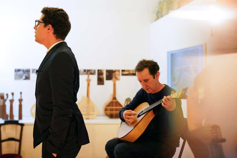 Un cantante de fado junto a un guitarrista