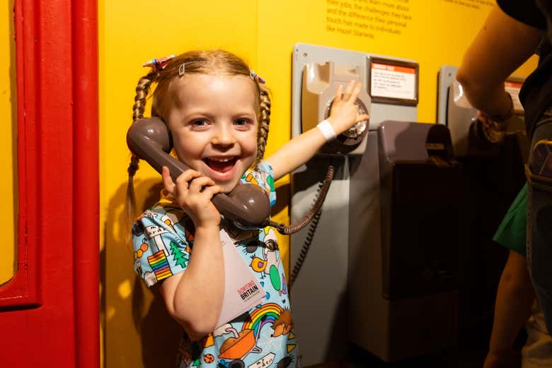 Una niña llamando con un teléfono antiguo