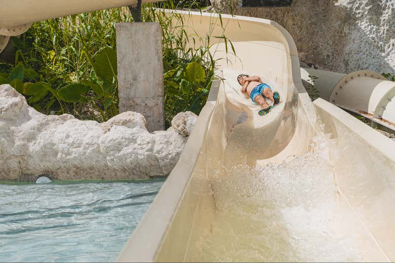 Um menino descendo por um dos toboáguas do parque