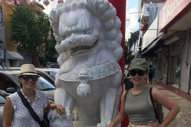 Junto a una escultura en el Barrio Chino