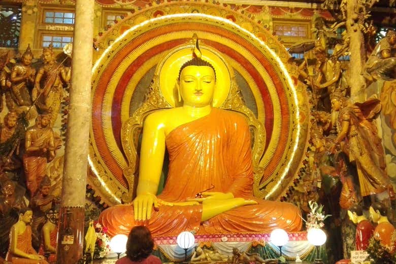 Marvel at the golden Buddha statue in the Gangarama Temple
