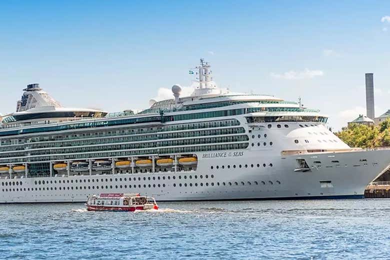 El barco turístico junto a un enorme crucero