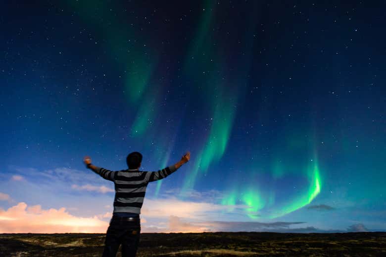 Un touriste admirant les aurores boréales