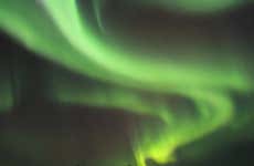 Paseo en moto de nieve bajo la aurora boreal