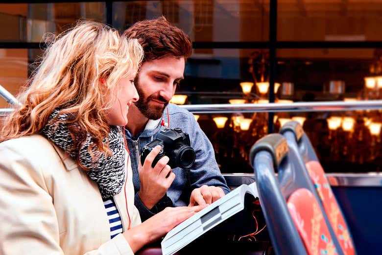 Um casal consultando um guia a bordo do ônibus de turismo