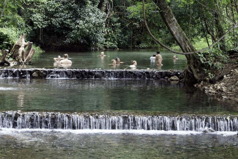 Gente disfrutando en las aguas termales de Sai Ngam