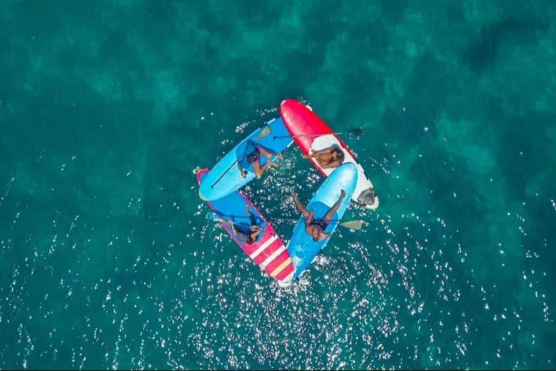 Foto aérea de gente haciendo yoga en tablas de paddle surf