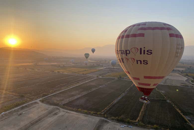 Un globo volando sobre Pamukkale al amanecer