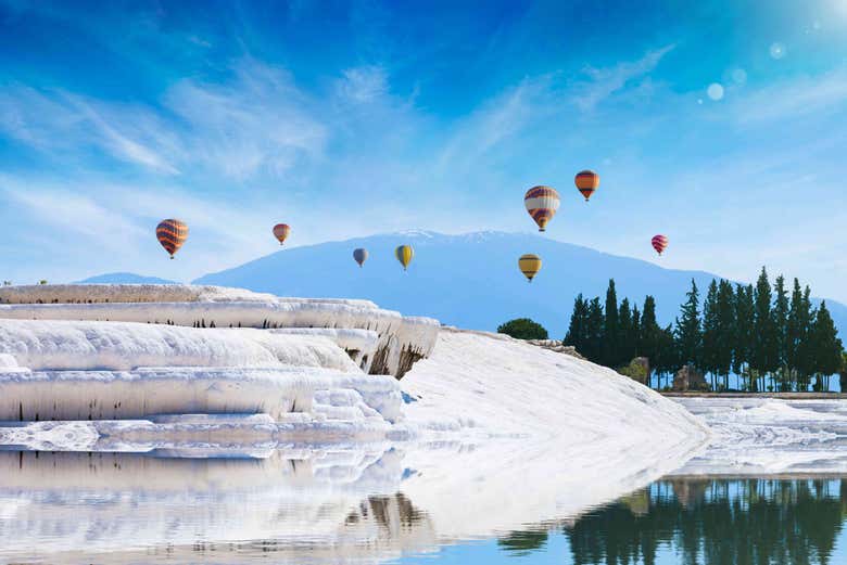 Paisaje de Pamukkale con globos volando a su alrededor