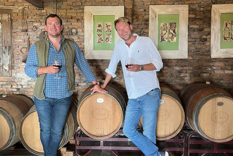 Tomando uma taça de vinho junto aos barris